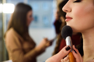 Beauty and health clean Skin of young female Model. Woman applying Powder Foundation with Brush.
