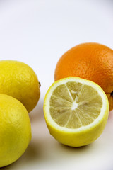Fototapeta na wymiar fresh fruits. Lemons and oranges sliced and whole