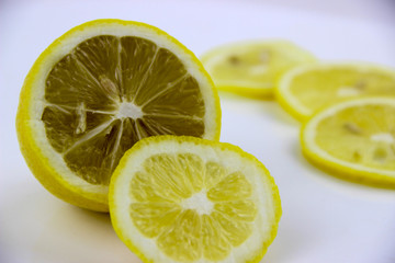 Naklejka na ściany i meble bright, yellow lemons. whole and sliced on a plate.
