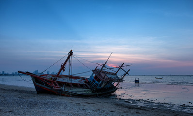 Fototapeta premium The Wreck was left on the beach with the beautiful twilight sky.