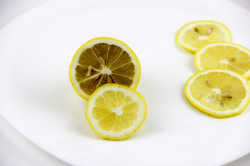 bright, yellow lemons. whole and sliced on a plate.