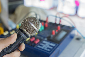 hand holding microphone, it is a concept about entertainment or mass communication