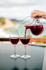 She pours the Sangria into two glasses 