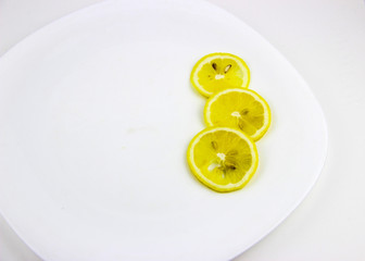 bright, yellow lemons. whole and sliced on a plate.
