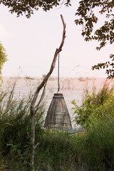 The random bamboo for catching fish is hanging on the wood branch.