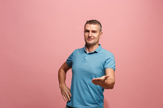 The young attractive man looking suprised isolated on pink