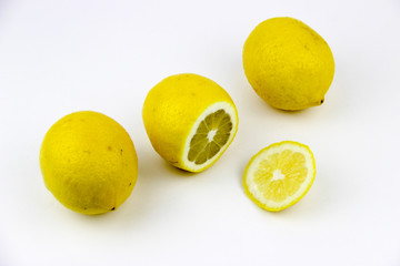 bright, yellow lemons. whole and sliced on a plate.
