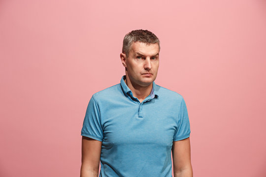 Suspiciont. Doubtful pensive man with thoughtful expression making choice against pink background