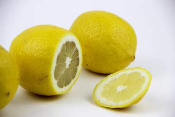 bright, yellow lemons. whole and sliced on a plate.
