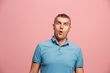 The young attractive man looking suprised isolated on pink