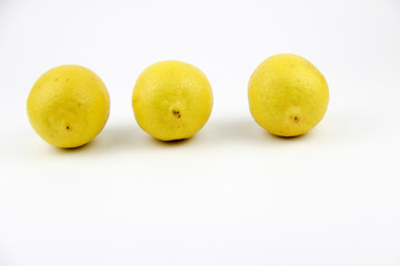 bright, yellow lemons. whole and sliced on a plate.
