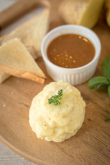Mashed potatoes in a plate on a wooden table