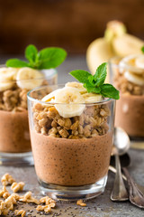 Layered chocolate chia pudding parfait with banana, granola and yogurt, dessert