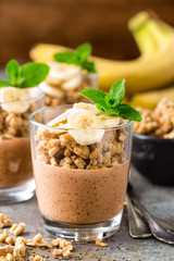 Layered chocolate chia pudding parfait with banana, granola and yogurt, dessert