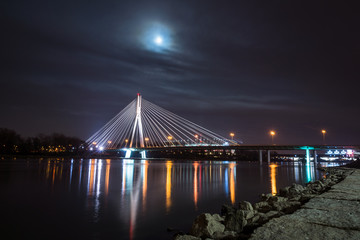 Fototapeta na wymiar Swietokrzyski bridge over the Vistula river at night in Warsaw, Poland