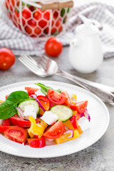 Tomato salad with fresh bell pepper, red onion and feta cheese. Healthy eating