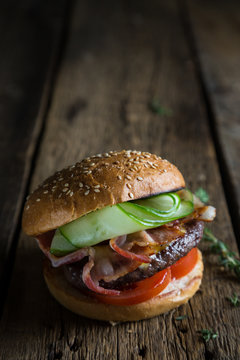 Big burger with bacon and fresh cucumber