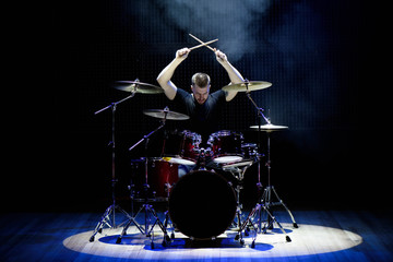 Drummer playing the drums with smoke and powder in the background - obrazy, fototapety, plakaty