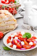 Tomato salad with fresh red onion and feta cheese. Healthy eating