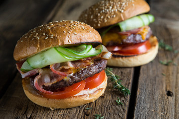 Big burger with bacon and fresh cucumber