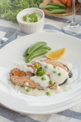 Grilled salmon steak with vegetables and white sauce
