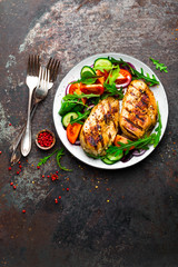 Grilled chicken breast. Fried chicken fillet and fresh vegetable salad of tomatoes, cucumbers and arugula leaves. Chicken meat with salad. Healthy food