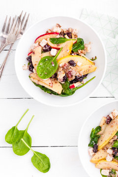 Healthy fruit and berry salad with fresh apples, cranberries, walnuts, italian ricotta cheese and spinach leaves. Delicious and nutritious diet dish for breakfast