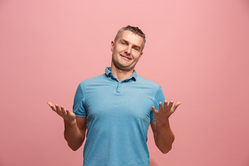 The happy business man standing and smiling against pink background.