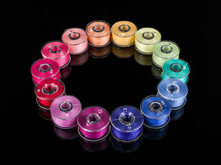 Bobbins with colorful threads on black