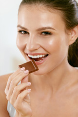 Woman Eating Chocolate. Beautiful Girl With Sweets.