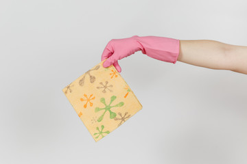 Close up of female hand in pink gloves horizontal holds patterned orange rag for cleaning and...