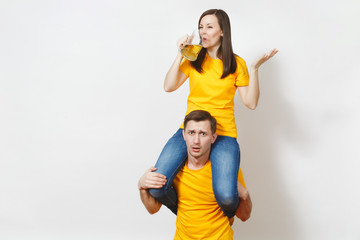 Fun inspired young couple woman sit on man shoulders, fans with pint mug of beer cheer favorite team, expressive gesticulate hands isolated on white background. Sport family leisure lifestyle concept.