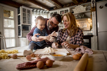 Happy family making pasta in the kitchen at home