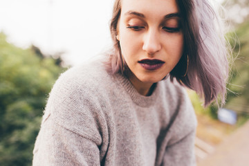 Portrait of young beautiful caucasian purple grey hair woman outdoor in the city looking over, smiling - happiness, carefree, serene concept