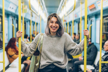 waist up young woman travelling underground looking camera smiling - traveller, commuter, happiness...