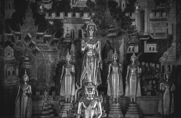 Ancient Buddha sculptures at Wat Uposatharam Temple or Wat Bot at noon under clear blue sky, Thailand
