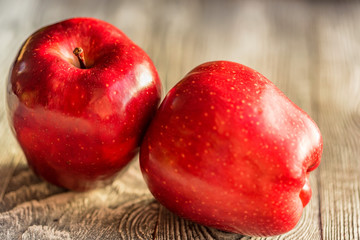 Red juice ripe apples on wooden background