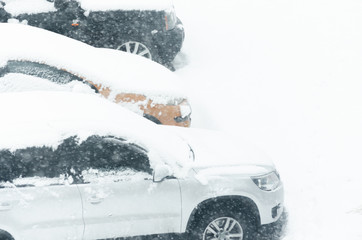 Cars were covered with a thick layer of snow during heavy snowfall, snow storm.