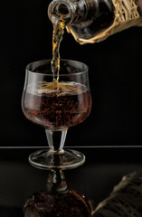Cognac is poured from a bottle into glass