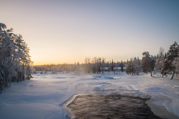 Half frozen Raudanjoki peat river on a winter day, Vaattunki, Finland. 