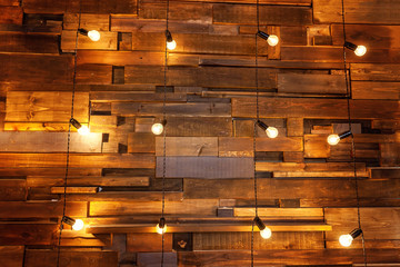 Hanging light bulb over the wooden background, mockup poster. Background wood planks with lamps