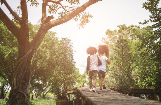 Children Friendship Togetherness Concept. African American Little Boy And Girl Hug Each Other In Summer Sunny Day Back View