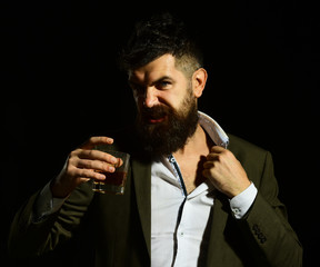 Businessman with beard and beverage on black background