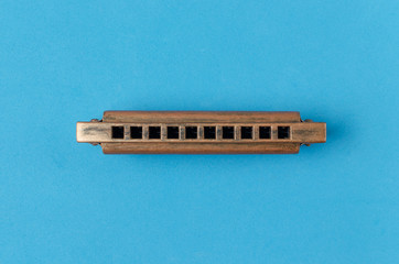 Old harmonica on a blue background.