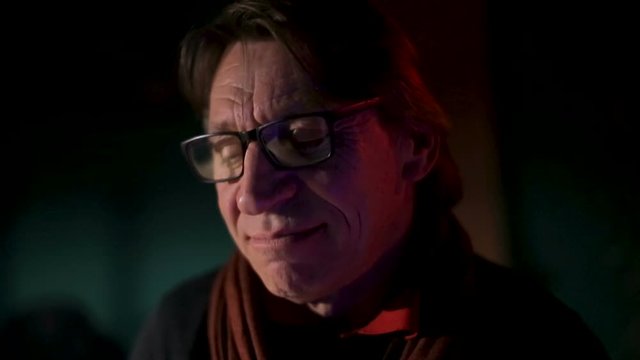 Senior old man sitting by the fireplace with happy thoughtfull expression