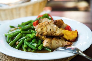 Roasted pork fillet with bacon, beans and peppers.