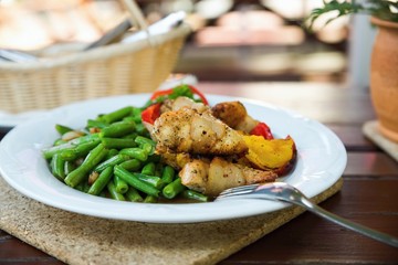 Roasted pork fillet wrapped in bacon , beans and peppers.