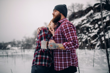 Young couple hugs during winter walk.