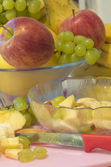 Many fresh fruits as ingredients for the vegan and healthy cuisine - text on knife: German for 