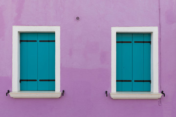 Purple wall of the house and stylish wooden shutters